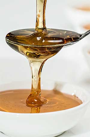 Honig fließt zäh von einem Teller